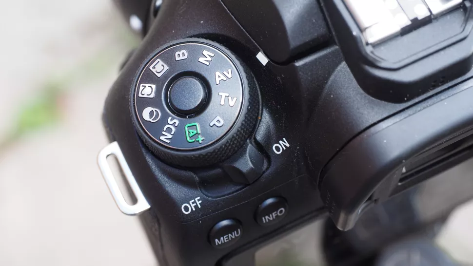 Canon EOS 90D Review 22 El dial de modo principal tiene un botón de bloqueo para evitar que se gire accidentalmente, lo cual es bueno, pero la gran palanca de potencia situada debajo se siente incómoda, ya que no se puede operar sin cambiar el agarre.